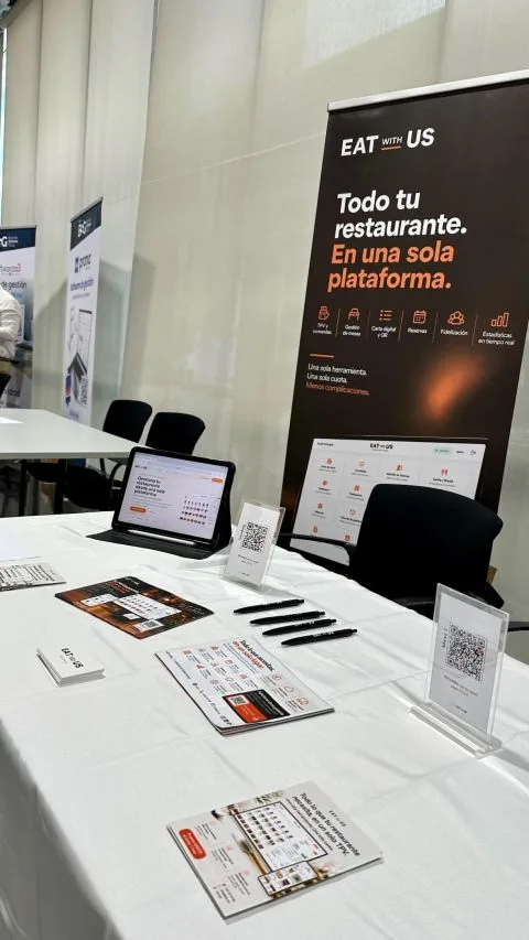 Mesa de Eat with Us con roll-up, tablet y folletos